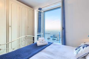 een slaapkamer met een bed en uitzicht op de oceaan bij Marina Grande,102 - Blue Horizon Sorrento in Sorrento