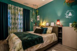 ein Schlafzimmer mit einem Bett mit grünen Wänden in der Unterkunft Idromassaggio Doppia - Dimora Zen Seregno in Seregno