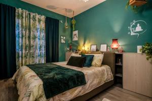 a bedroom with a bed with green walls at Idromassaggio Doppia - Ango House Seregno in Seregno