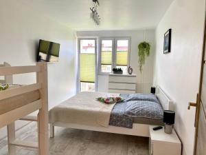 a small bedroom with a bed and a staircase at Apartament Słoneczny Ustka in Ustka