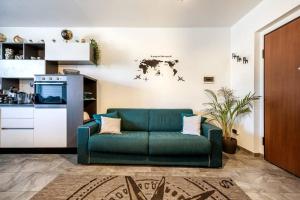 a living room with a green couch and a kitchen at Idromassaggio Doppia - Dimora Zen Seregno in Seregno