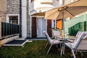 a patio with a table and chairs and an umbrella at Idromassaggio Doppia - Dimora Zen Seregno in Seregno