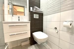 a white bathroom with a toilet and a sink at Apartament Słoneczny Ustka in Ustka +27 photos