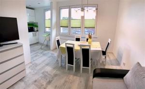a kitchen and dining room with a table and chairs at Apartament Słoneczny Ustka in Ustka
