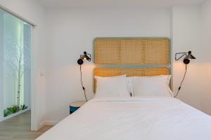 a bedroom with a large white bed with two lamps at Amazing Setúbal in Setúbal