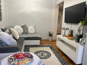 ein Wohnzimmer mit einem Sofa und einem TV in der Unterkunft Apartment Luxe FREE WIFI, FREE PARKING, FREE NETFLIX in Friern Barnet