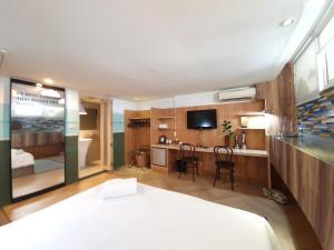 ein Schlafzimmer mit einem Bett und ein Wohnzimmer in der Unterkunft Somewhere to Escape - Hometel in Bangkok