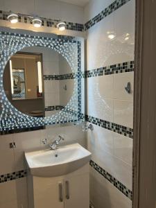 a bathroom with a sink and a mirror at Apartment Luxe FREE WIFI, FREE PARKING, FREE NETFLIX in Friern Barnet