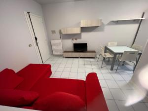 a living room with a red couch and a table at Appartamento Civico 23 in Brescia