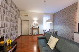 - un salon avec un canapé et un mur en briques dans l'établissement My Charming Apartments in Centro Città-San Lorenzo Suite, à Milan