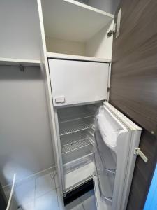 un frigorifero vuoto con la porta aperta in una cucina di Appartamento Civico 23 a Brescia