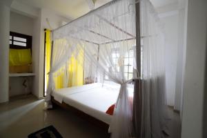 Cette chambre comprend un lit à baldaquin. dans l'établissement Happy Rest By Chill House, à Unawatuna