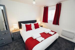 a bedroom with a large white bed with red pillows at The Stay Company, Phoenix Court in Nottingham