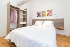 - une chambre avec un lit blanc et un placard dans l'établissement Tintin - Locationtournus, à Tournus