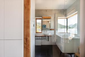 ein Badezimmer mit einer Badewanne, einem Waschbecken und einem Spiegel in der Unterkunft Stunning Holiday Rental by the Waterfront in Sogndal