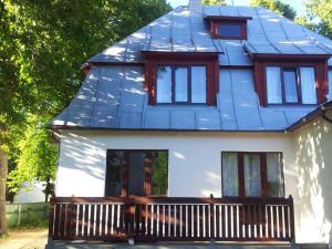 a house with a blue roof with a porch at Janno apartment in Pärnu