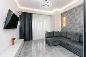 a living room with a couch and a flat screen tv at Luxury Apartment in Chişinău