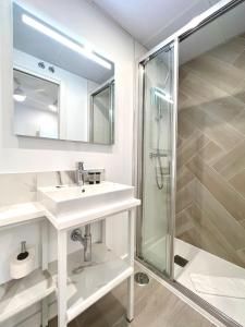 biała łazienka z umywalką i prysznicem w obiekcie BNBHolder MUSEO DEL PRADO es MIA w Madrycie