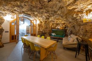 - une salle à manger dans une grotte avec une table et des chaises dans l'établissement Casa Manuela, à Ribera Baja