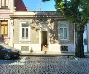 una casa con un coche aparcado delante en aDuquesa - GuestHouse, en Oporto