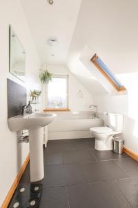 a white bathroom with a sink and a toilet at Cuillich Mill Bed and Breakfast in the Highlands in Alness