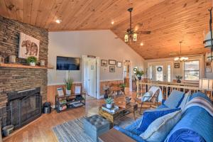 a living room with a blue couch and a fireplace at Lakemont Mtn Cabin with Game Room and Hot Tub! in Lakemont