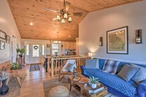 a living room with a blue couch and a wooden ceiling at Lakemont Mtn Cabin with Game Room and Hot Tub! in Lakemont