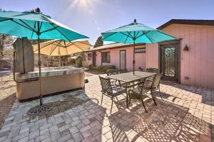 un patio con mesa y 2 sombrillas en Pet Friendly Sedona Home with Private Hot Tub en Sedona