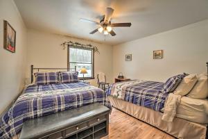 a bedroom with two beds and a ceiling fan at Houghton Lake Cottage Escape with Patio! in Houghton Lake