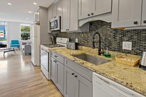 a kitchen with white cabinets and a sink at Boutique Blue 2 bedroom Old Town House in Alexandria