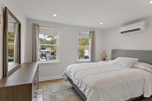 a white bedroom with a large bed and windows at Boutique Blue 2 bedroom Old Town House in Alexandria