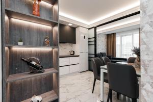 a kitchen and dining room with a table and chairs at Luxury Apartment in Chişinău