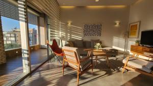 - un salon avec un canapé, une table et des chaises dans l'établissement White Night by Holyguest, à Tel Aviv