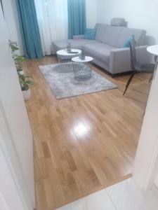 a living room with a couch and a wooden floor at Sofija City BL in Banja Luka