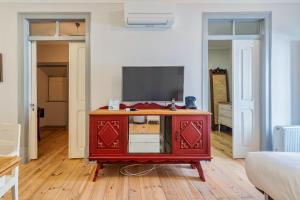 a living room with a tv and a red cabinet at Carmo´s Residence Art Apartments 2º in Setúbal