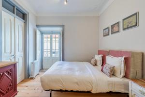 a bedroom with a large white bed with pillows at Carmo´s Residence Art Apartments 2º in Setúbal