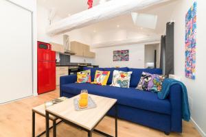 a living room with a blue couch and a table at Le Graff - Locationtournus in Tournus