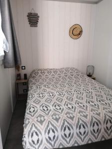a bedroom with a bed with a quilt on it at Cottage chaleureux Louann in Labouheyre