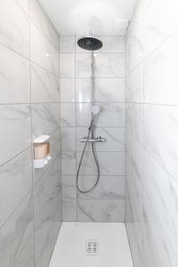 La salle de bains est pourvue d'une douche avec du carrelage blanc. dans l'établissement Le Graff - Locationtournus, à Tournus