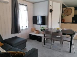 a living room with a table and a couch at Cottage chaleureux Louann in Labouheyre