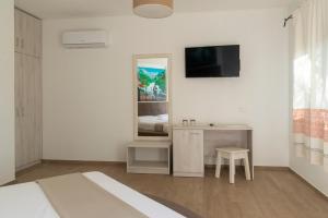 a bedroom with a bed and a desk and a mirror at Hotel Villa Cedrino in Dorgali