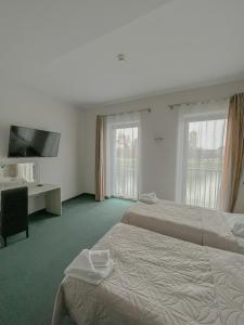 Habitación de hotel con 2 camas y TV de pantalla plana. en Hotel Poleski en Cracovia