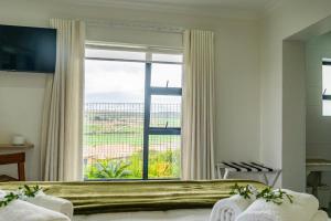 a bedroom with a large window with a view at Verdant Hills in Reebok