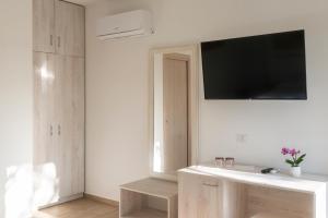 a bathroom with a sink and a tv on the wall at Hotel Villa Cedrino in Dorgali