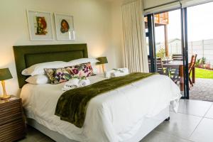 a bedroom with a large white bed with a balcony at Verdant Hills in Reebok