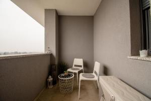 een klein balkon met 2 stoelen en een tafel bij Flexible SelfCheckIns 41 - Zagreb - Luxury - Parking - Loggia - Brand New in Zagreb