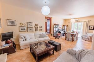 a living room with a white couch and a tv at Villa Dionisia, Relaxation with Jacuzzi Retreat in Svoronata