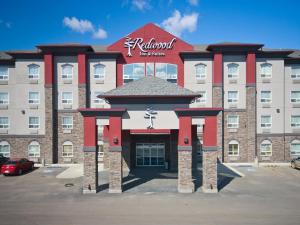 Redwood Inn & Suites في Clairmont: فندق ذو مبنى احمر وابيض