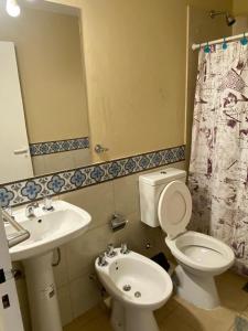 y baño con aseo, lavabo y espejo. en DEPARTAMENTO DON GENARO en Villa Carlos Paz