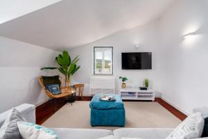 a living room with a couch and a tv at Setubal Downtown N97, By Home Match in Setúbal